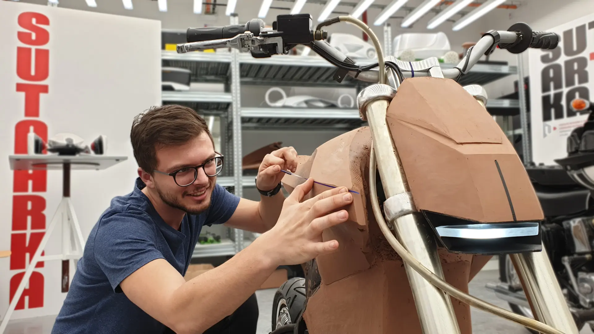 Designer sculpting the full-scale clay model of the E-moto front fairing